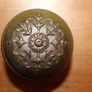May include: A vintage brass door knob with an ornate floral design.