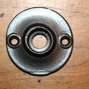 May include: Black metal door knob backplate with two holes for screws.