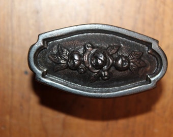 May include: A black metal cabinet knob with an ornate design featuring roses and leaves.