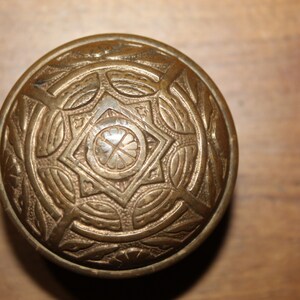 May include: A brass door knob with an intricate, star-shaped design.