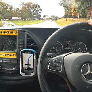 Puede incluir: Vista interior del salpicadero de un veh&iacute;culo, con un volante con el logotipo de Mercedes-Benz. Un dispositivo GPS muestra un mapa. Pegatinas amarillas con las frases "AVOID BACKING UP" y "WHENEVER POSSIBLE".