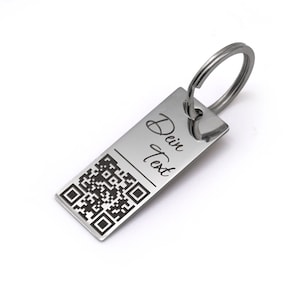 Può includere: Portachiavi in ​​argento con un codice QR in bianco e nero e il testo "Dein Text" inciso.