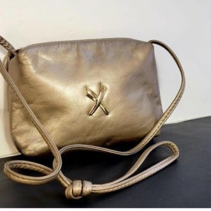 Bolso bandolera pequeño de piel color champán con detalle en forma de X dorada, elegante bolso de hombro para mujer, bolso compacto para tus artículos esenciales de diario.
