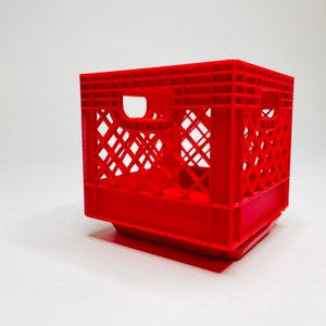 Puede incluir: Una caja de leche de pl&aacute;stico rojo brillante con forma rectangular y dise&ntilde;o de celos&iacute;a. La caja tiene dos aberturas para asas en los lados. Este contenedor de almacenamiento es adecuado para diversos usos.