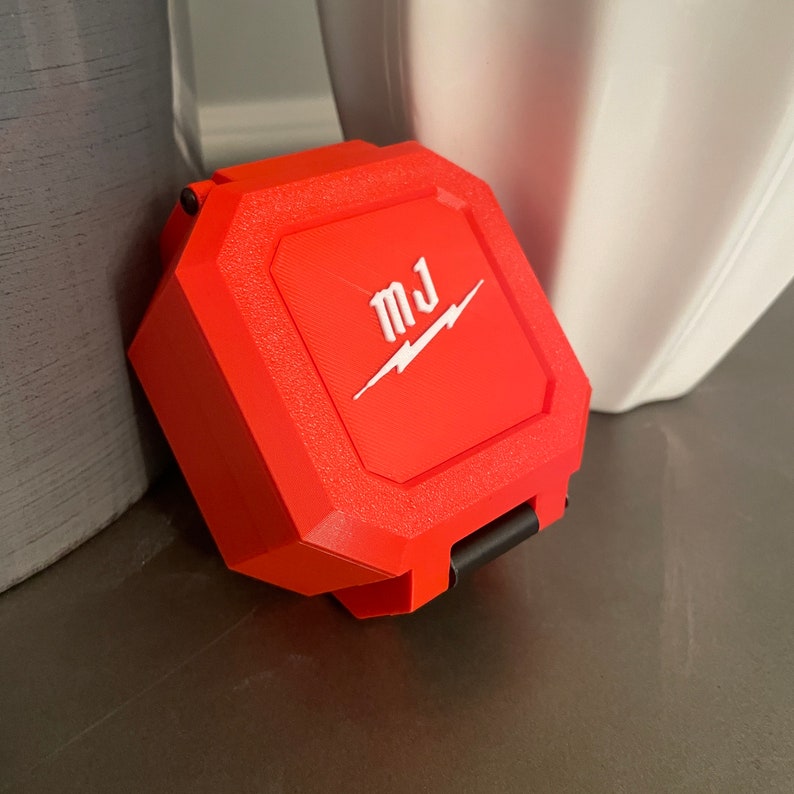 May include: A bright red, octagonal-shaped case with a black latch. The case has a white lightning bolt and the initials "MJ" printed on the top.