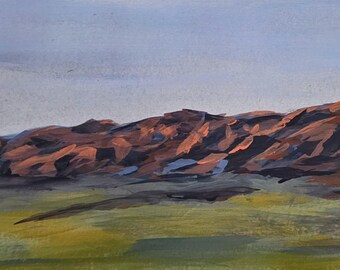 May include: An original landscape painting depicting a mountain range under a pale blue sky. The mountains are rendered in shades of brown and red, with darker shadows. The foreground features a green and brown field.