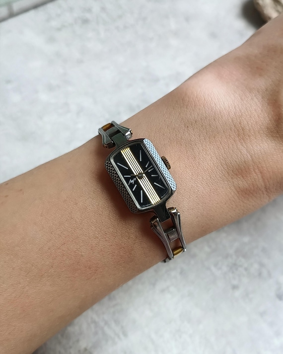 Miniature vintage rectangular women's watch, mechanical, with a black and gold dial, 1980s.