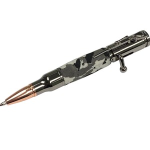 May include: A silver and black tactical pen with a camouflage pattern and a bullet-shaped tip. The pen has a retractable tip and a side-mounted clip.