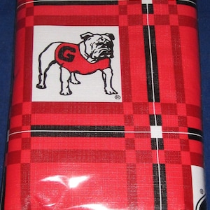 May include: Red and black plaid tablecloth with a white bulldog wearing a red jersey with a white "G" on it. The bulldog is in the center of the tablecloth.