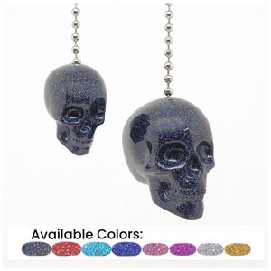 May include: A black glitter skull fan pull with a silver chain. Available colors: black, red, teal, blue, pink, purple, silver, gold.