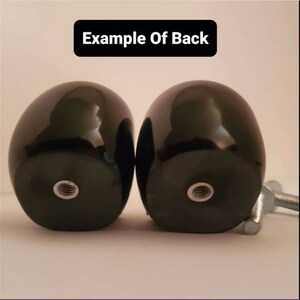 May include: Two black, round, smooth, wooden knobs with a threaded hole in the center. The knobs are attached to a metal screw.