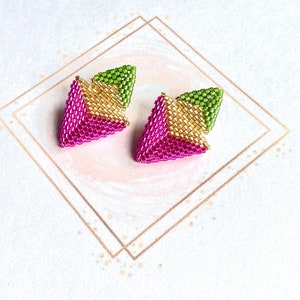 May include: A pair of geometric earrings with a pink, gold, and green color scheme. The earrings are made of small beads and have a triangular shape.