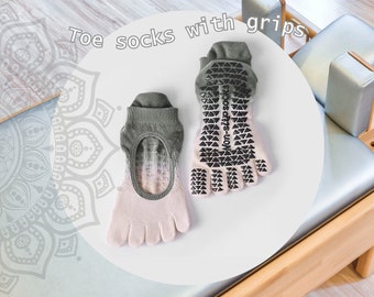 May include: Toe socks with grips. Two pairs of toe socks are displayed. The socks are light pink and gray with a non-slip grip pattern on the soles. The text "Toe socks with grips" is above the socks.