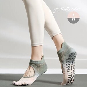 May include: A pair of gray and white yoga socks with a non-slip grip sole. The socks have a toe separator design and a cut-out on the top of the foot. The text "gradient color" and the letter "A" are visible in the image.