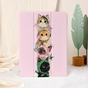 May include: Pink tablet case featuring a stack of four cartoon cats wearing hats and accessories. The cats are in various colors, including orange, brown, and black. A disco ball and stars are also included in the design.