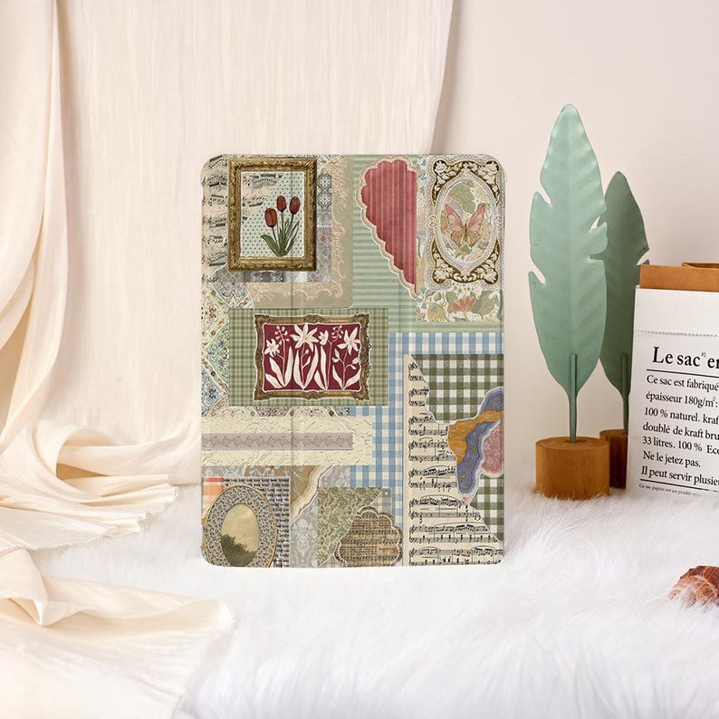 May include: A tablet case with a patchwork design of vintage images. The case features framed floral prints, a heart shape, and musical notes, in shades of green, blue, and beige. The rectangular case is likely made from a durable material, suitable for protecting a tablet.