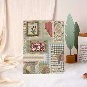 May include: A decorative journal cover with a collage of vintage images and patterns. The design includes framed floral art, a butterfly, musical notes, and a gingham pattern. The colour palette is soft, with greens, reds, and creams.