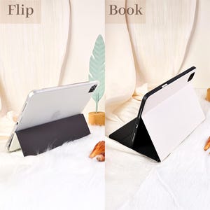 May include: Two views of a tablet with a protective case. The left side shows the tablet in a flip position, supported by the case. The right side shows the tablet in a book position, with the case acting as a stand. The case is black and white.