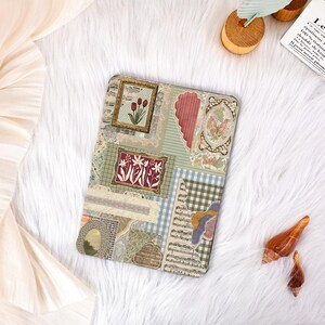 May include: A decorative tablet case with a collage of vintage patterns and framed botanical illustrations. The design includes floral motifs, a butterfly, and musical notes, in greens, blues, and reds. The case is rectangular.