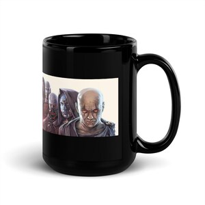 Könnte beinhalten: Schwarze Keramik-Tasse mit einer detaillierten Illustration mehrerer Figuren mit intensiven Gesichtsausdrücken und roten Augen. Das Kunstwerk ist vor einem hellen Hintergrund platziert, was einen auffälligen Kontrast zur dunklen Farbe der Tasse erzeugt. Die Tasse hat einen großen Henkel.