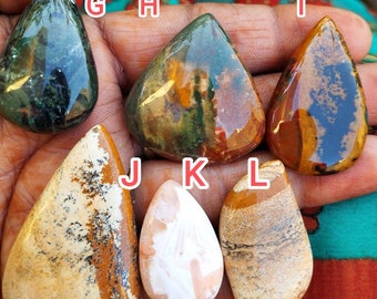 May include: Six polished, teardrop-shaped cabochon gemstones labeled G through L. Gemstone G is dark green, H is mottled green and orange, I is amber and black, J is cream with brown and black patterns, K is pale pink, and L is tan with brown stripes.