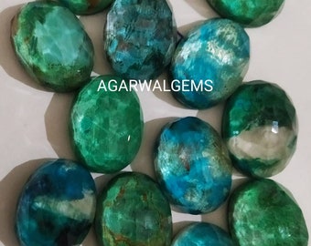 Könnte beinhalten: Eine Ansammlung von zwölf ovalen, facettierten Edelsteinen in den Farben Dunkelgrün, Blaugrün und Blau mit natürlichen Einschlüssen. Die Steine sind in einer Gruppe angeordnet und der Text AGARWALGEMS ist in Weiß in der Mitte abgebildet.