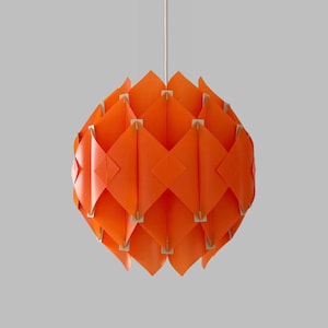 May include: Orange pendant light fixture with a geometric design. The light is made of many small, overlapping panels that create a unique and modern look.
