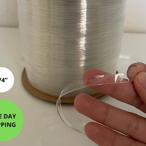 Op de afbeelding: Een rol doorzichtige, 6,35 mm brede plastic band. De band is flexibel en kan worden gebruikt om pakketten te beveiligen.