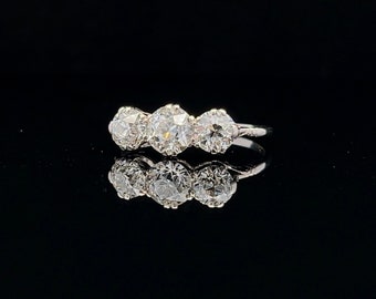 May include: A silver ring with three round diamonds set in a row.