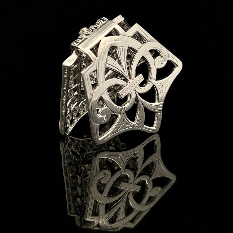 May include: A silver filigree hair clip with a decorative floral design. The clip is open and ready to be used.