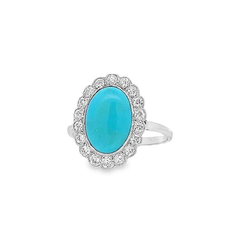 May include: A silver ring featuring a turquoise oval gemstone set within a halo of small diamonds.