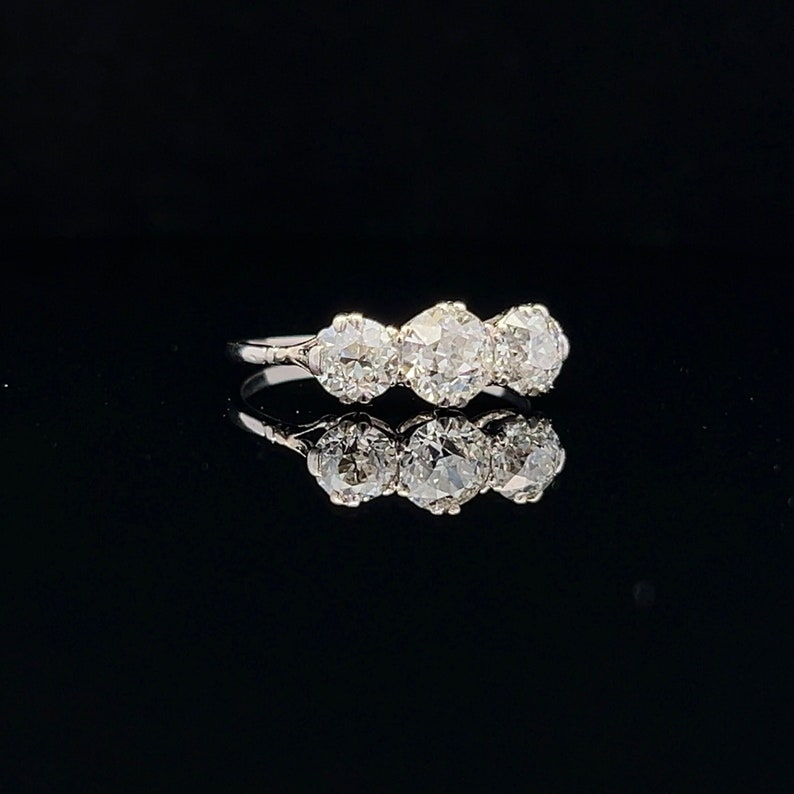 Puede incluir: Un anillo de plata con tres diamantes redondos engastados en fila.