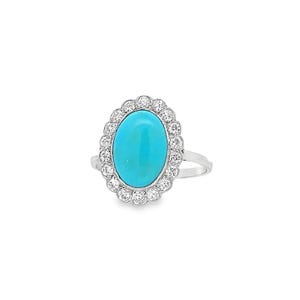 May include: A silver ring featuring a turquoise oval gemstone set within a halo of small diamonds.
