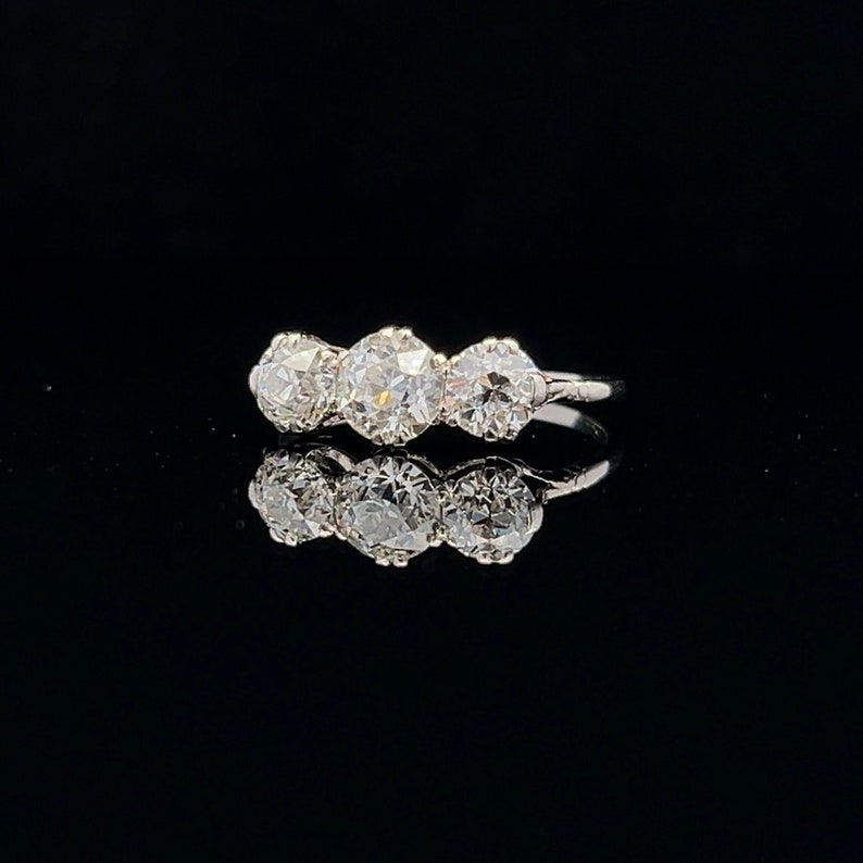 Puede incluir: Un anillo de plata con tres diamantes redondos engastados en fila.