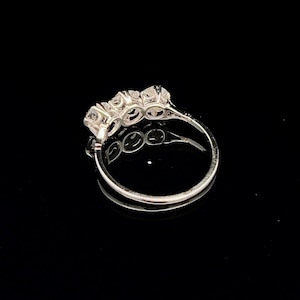 Puede incluir: Un anillo de banda de plata con cinco piedras redondas transparentes engastadas en una fila.