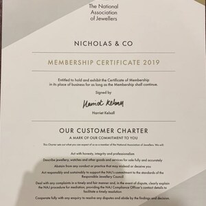 May include: A white membership certificate for Nicholas & Co. from the National Association of Jewellers. The certificate is dated 2019 and states that the business is entitled to hold and exhibit the certificate for as long as the membership continues. The certificate is signed by Harriet Kelsall.