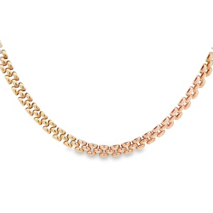 May include: A gold chain necklace with a two-tone design. The chain is made of interlocking links, creating a classic and elegant look.