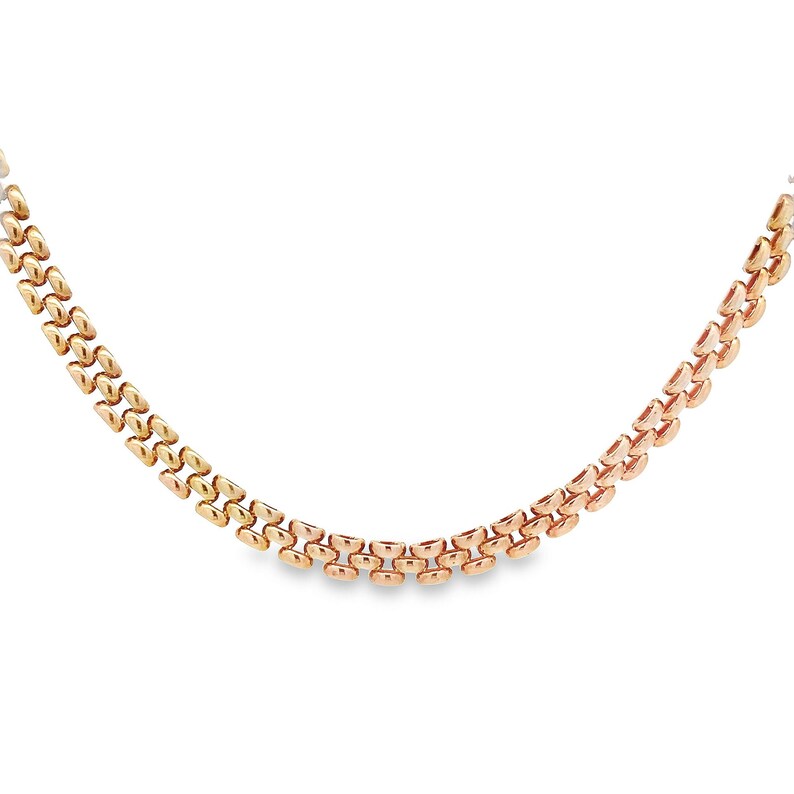 May include: A gold chain necklace with a two-tone design. The chain is made of interlocking links, creating a classic and elegant look.