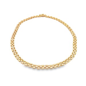 May include: A gold chain necklace with a delicate, interlocking pattern. The chain is made of small, oval-shaped links that are connected in a repeating pattern.
