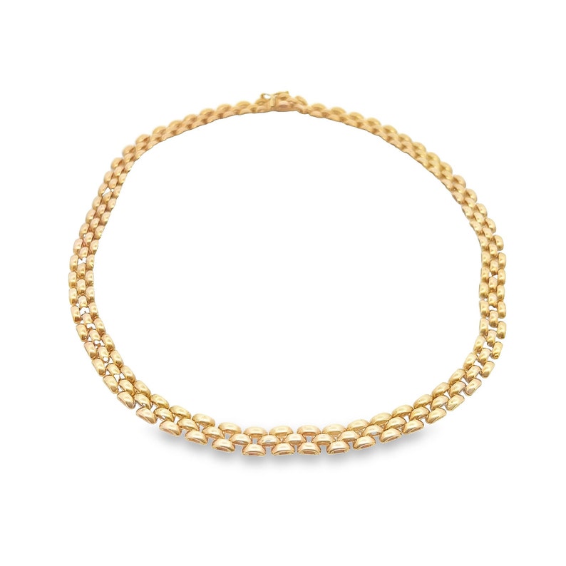 May include: A gold chain necklace with a delicate, interlocking pattern. The chain is made of small, oval-shaped links that are connected in a repeating pattern.