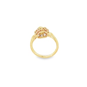 May include: A gold ring with a heart-shaped design and a row of small clear stones around the edge.