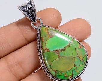 May include: A teardrop-shaped pendant featuring a polished green turquoise stone with brown matrix veins, set in a decorative sterling silver frame with intricate scrollwork details on the bail and a beaded edge around the gemstone setting.