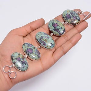 Könnte beinhalten: Ein silbernes Armband mit vier ovalen, grün-rosa Steinen. Die Steine haben ein gesprenkeltes Muster.