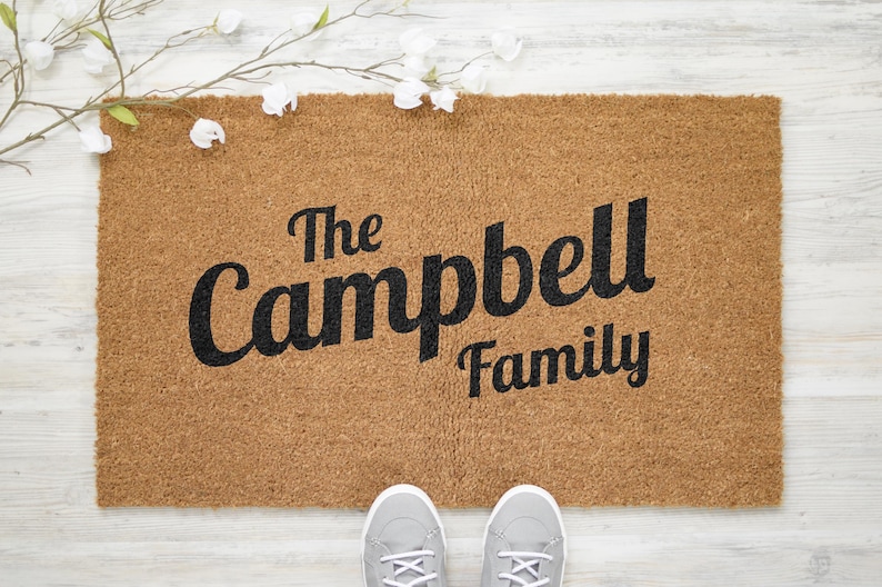 May include: A brown coir doormat with the text "The Campbell Family" in black lettering.