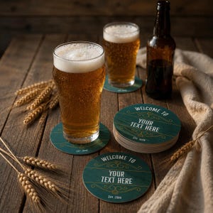 Può includere: Due bicchieri da birra trasparenti riempiti di birra dorata, una bottiglia di birra in vetro marrone scuro e tre sottobicchieri rotondi verde scuro con venature del legno. I sottobicchieri riportano il testo "WELCOME TO YOUR TEXT HERE EST. 2026".