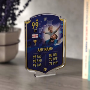 May include: A personalised acrylic football card featuring a photo of a father and child. The card has a blue and gold design, the number 99, the text "ST", and "ANY NAME". Player stats are also displayed on the card.