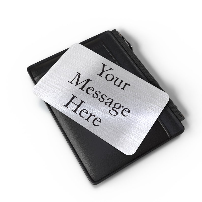Puede incluir: Una cartera de cuero negro con una placa de metal plateado que dice "Your Message Here".