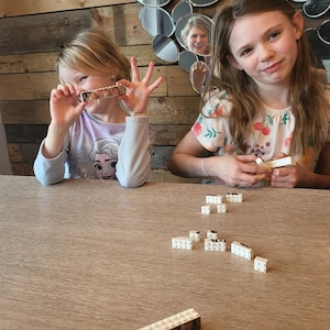 Personalised Father’s Day gift featuring a custom photo printed on a Lego-style brick plaque with the text “Daddy & Me.” The unique keepsake shows a child sitting on their father’s shoulders, displayed on a wooden surface with a red heart detail and decorative items nearby.