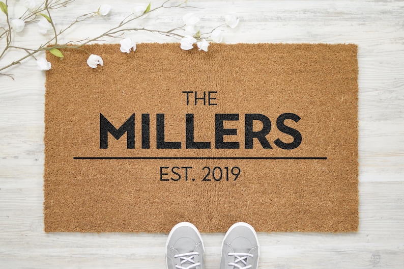 May include: A brown coir doormat with the text "THE MILLERS EST. 2019" in black lettering.