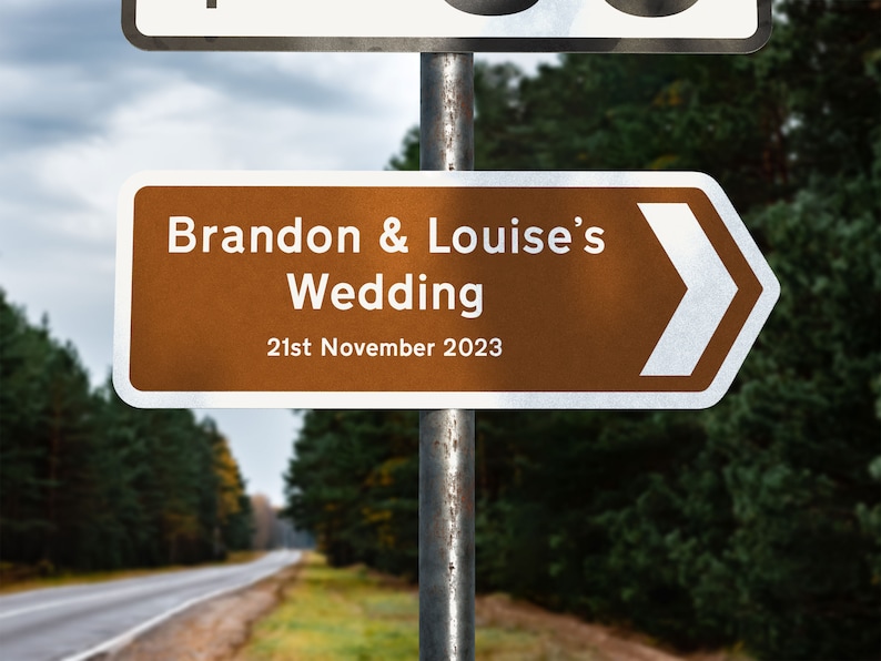 May include: A brown and white directional sign with an arrow pointing to the right. The sign reads "Brandon & Louise's Wedding 21st November 2023".
